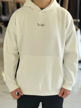Canguro oversize de color beige claro con capucha, mangas largas y puños elastizados. Presenta un diseño gráfico en la espalda con el texto 'Creative Thinking' en tipografía cursiva negra sobre un fondo de letras grandes en tono rosado.