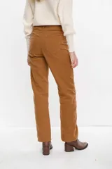 Jean tiro alto color camel, de corte semi-oxford con doble botón en la pretina y tajo delantero en el ruedo.