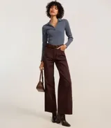 Blusa de manga larga confeccionada en tejido rib de algodón con elastano. Presenta un diseño ajustado al cuerpo con cuello polo y escote en V.