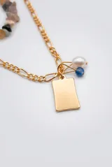 Collar doble dorado con una tira de piedras naturales multicolor y otra cadena de eslabones con dije rectangular liso y perlas colgantes.