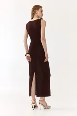 Vestido midi marrón sin mangas, de punto suave, con escote drapeado y cuentas decorativas irregulares en el tirante derecho. Presenta frunces en el lateral con efecto drapeado.