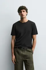 Camiseta de corte ajustado confeccionada en tejido de algodón con elasticidad, cuello redondo y manga corta.