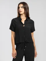 Camisa negra de manga corta en crepé de viscosa suave, con cuello camisero y detalle floral en la botonadura central.