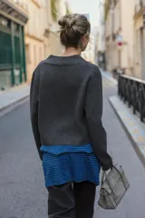 Chaqueta de punto gris oscuro con escote en pico, manga larga y cierre frontal con tres botones.