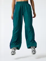 Pantalón ancho de microfibra, de corte holgado estilo retro vintage, en color verde oscuro con franjas laterales en contraste de color azul.