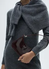 Vestido corto de punto en color gris, con cuello redondo y manga larga. Presenta un diseño recto y minimalista confeccionado en una mezcla de fibras.