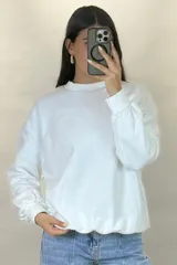 Buzo de cuello redondo, corte oversize, con mangas largas y puños elásticos.