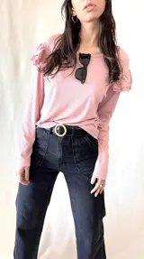 Remera de punto color rosa con mangas largas y volados en los hombros.