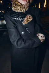 Guantes cortos de cuero sintético negro con costuras decorativas en el dorso y puño con aplicación de pelo sintético estampado con diseño animal print.