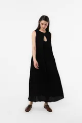 Vestido midi sin mangas de color marrón, confeccionado con textura arrugada, escote redondo, silueta relajada y caída liviana, con un lazo fino ajustable en la cintura.