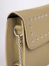 Bandolera rectangular color verde oliva, de símil cuero, con correa fija de cuero y cadena metálica. Tiene detalle de tachas plateadas en la solapa y broche a presión metálico.