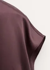 Blusa de seda con cuello alto y diseño sin mangas, de corte recto y acabado satinado.