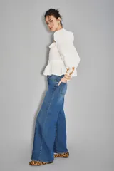 Jean de corte oxford y tiro medio, confeccionado en denim de color azul clásico. Presenta un diseño de pierna ancha y holgada, con cierre frontal y bolsillos laterales y traseros.