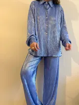 Camisa plisada color celeste con brillo, de corte holgado y manga larga con puños elásticos.