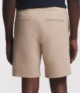 Bermuda recta de sarga color beige para hombre, con cintura elástica y cordón ajustable. Cuenta con bolsillos laterales y está confeccionada en una mezcla de algodón y elastano.