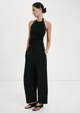 Top negro de algodón con diseño entallado, cuello halter y ribetes de encaje en los hombros y cuello. No incluye mangas.