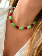 Collar de cuentas cilíndricas y ovaladas alternadas en colores verde jaspeado y fucsia traslúcido, con pequeñas cuentas metálicas separadoras.