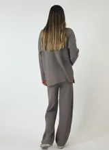 Conjunto de sweater y pantalón de punto acanalado color beige. El sweater es de corte holgado y el pantalón es de corte palazzo.