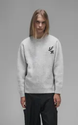Sweater de cuello redondo color gris melange, con diseño de punto texturado y bordado en relieve con las letras 'Lx.' en el pecho. Presenta terminaciones en punto rib en cuello, puños y ruedo.
