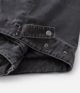 Chaqueta de denim color gris con acabado estonado, cierre frontal con cremallera, cuello camisero y manga larga. Presenta un estampado con la palabra 'OUTLAW' en tipografía gótica en el pecho y un bolsillo con cierre en la manga izquierda.