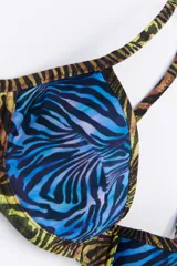 Bikini de dos piezas en combinación de colores negro y mostaza. El corpiño es de estilo triangular con base y breteles finos, mientras que la bombacha es de corte clásico con cintura alta en color negro.