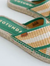 Sandalias tipo alpargata con suela de yute trenzado y tiras cruzadas en tejido de lino a rayas en tonos beige y blanco, con bordes en color verde.
