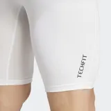 Short de compresión deportivo Adidas Techfit, color blanco con logo negro en la pierna izquierda y cintura elástica negra con la inscripción "Techfit" en blanco.