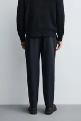 Pantalón regular fit color azul marino, confeccionado en tejido elástico. Cuenta con bolsillos frontales, bolsillos traseros de vivo con botón y cierre frontal con cremallera y botón.