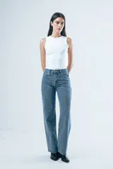 Pantalón de jean corte wide leg, color beige con estampado de rayas verticales finas. Presenta tiro alto, cierre frontal con botón y bolsillos laterales.