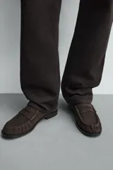 Mocasín de vestir confeccionado en piel con acabado de serraje, presenta un diseño clásico con detalle de antifaz en el empeine y suela a contraste con un ligero tacón.
