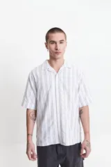 Camisa de manga corta a rayas verticales blancas y grises, con cuello camisero y corte recto. El modelo usa talle M.