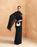 Vestido largo negro con escote bardot, detalle de nudo en la parte delantera y abertura lateral.