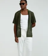 Pantalón masculino relaxed fit confeccionado en oxford de algodón, color beige, con trabillas en la cintura y cordón ajustable con lazo. Cuenta con bolsillos delanteros y traseros.