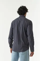 Camisa rústica lisa de manga larga color verde militar, con cuello clásico y dos bolsillos frontales con solapa.