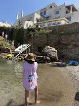 Camisa oversize de lino a rayas blancas y rosadas, con mangas largas y diseño bordado de peces en la espalda.