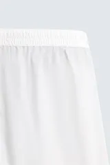 Pijama de dos piezas confeccionado en popelín de algodón blanco, con vivos de ribete en color bordó. Incluye una camisa de manga larga con cuello bowling, bolsillos de plastrón y cierre frontal de botones, y un pantalón de corte relajado con cintura elástica y bolsillos laterales.