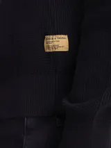 Sweater de cuello redondo confeccionado en algodón grueso con textura acanalada, de corte clásico y manga larga.