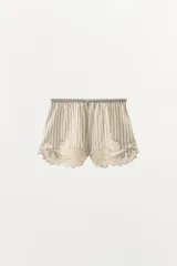 Shorts de tiro medio y cintura elástica, confeccionados en mezcla de algodón y viscosa con diseño de rayas verticales. Presenta el bajo acabado con aplicación de encaje y bordados en contraste.
