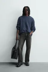 Jersey de punto con diseño de trenzas, cuello redondo y manga larga. Presenta un ajuste oversized y acabados en rib en puños y ruedo.