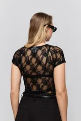 Top de encaje blanco con diseño ajustado al cuerpo, mangas cortas y detalle de cut-out en el escote.