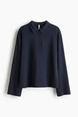 Remera polo de manga larga y corte holgado en punto de algodón, con cuello clásico, tapeta con tres botones y hombros caídos.