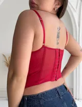 Corset rojo de encaje con transparencias y tirantes finos.