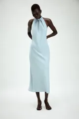 Vestido midi de satén color celeste, con cuello halter y detalle de lazada en la espalda descubierta.