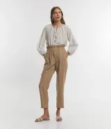 Pantalón carrot color beige confeccionado en viscosa, con cierre delantero en cremallera y cintura elástica.