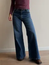 Pantalón de jean estilo wide leg con tiro alto, corte recto y amplio desde la cadera hasta el ruedo. Presenta un lavado azul clásico con sutiles detalles de textura.