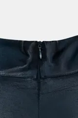 Vestido corto de cuello subido y sin mangas, confeccionado en tejido satinado. Presenta un detalle de fruncido lateral con abertura frontal y aplicación de encaje en el bajo.