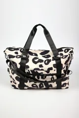 Bolso tipo duffel con estampado animal print en tonos crema y negro. Cuenta con correas de mano y correa ajustable para el hombro en color negro, cierre principal superior y bolsillo frontal con cierre.