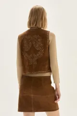 Falda corta de cuero color marrón, con diseño de flecos largos desmontables que cubren toda la prenda. Presenta un estilo western con cierre en la cintura.