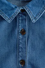 Camisa de denim de mezcla de algodón y lyocell, de corte corto, con cuello clásico, mangas largas abullonadas y cierre frontal con botones oscuros.