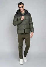 Campera puffer verde militar con capucha negra de cuero sintético, cierre frontal con cremallera y bolsillos laterales con cierre.